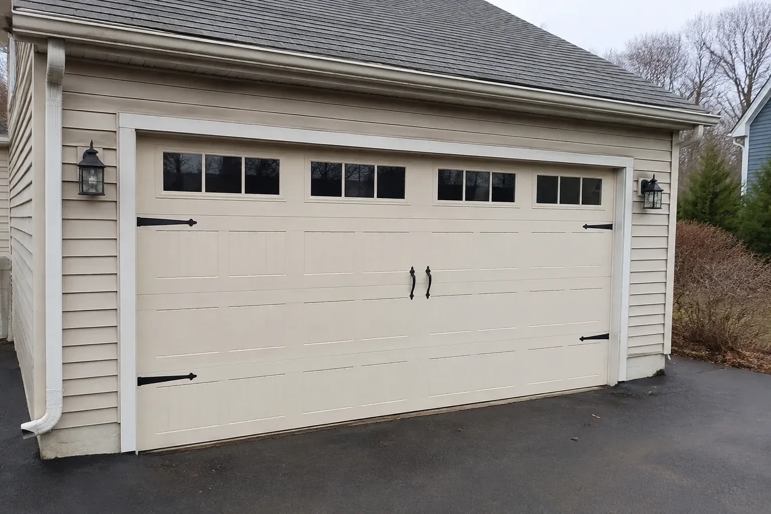 Cream carriage-house-style garage door with dark decorative hardware. — Carriage-House Garage Door Installation, Richmond Hill