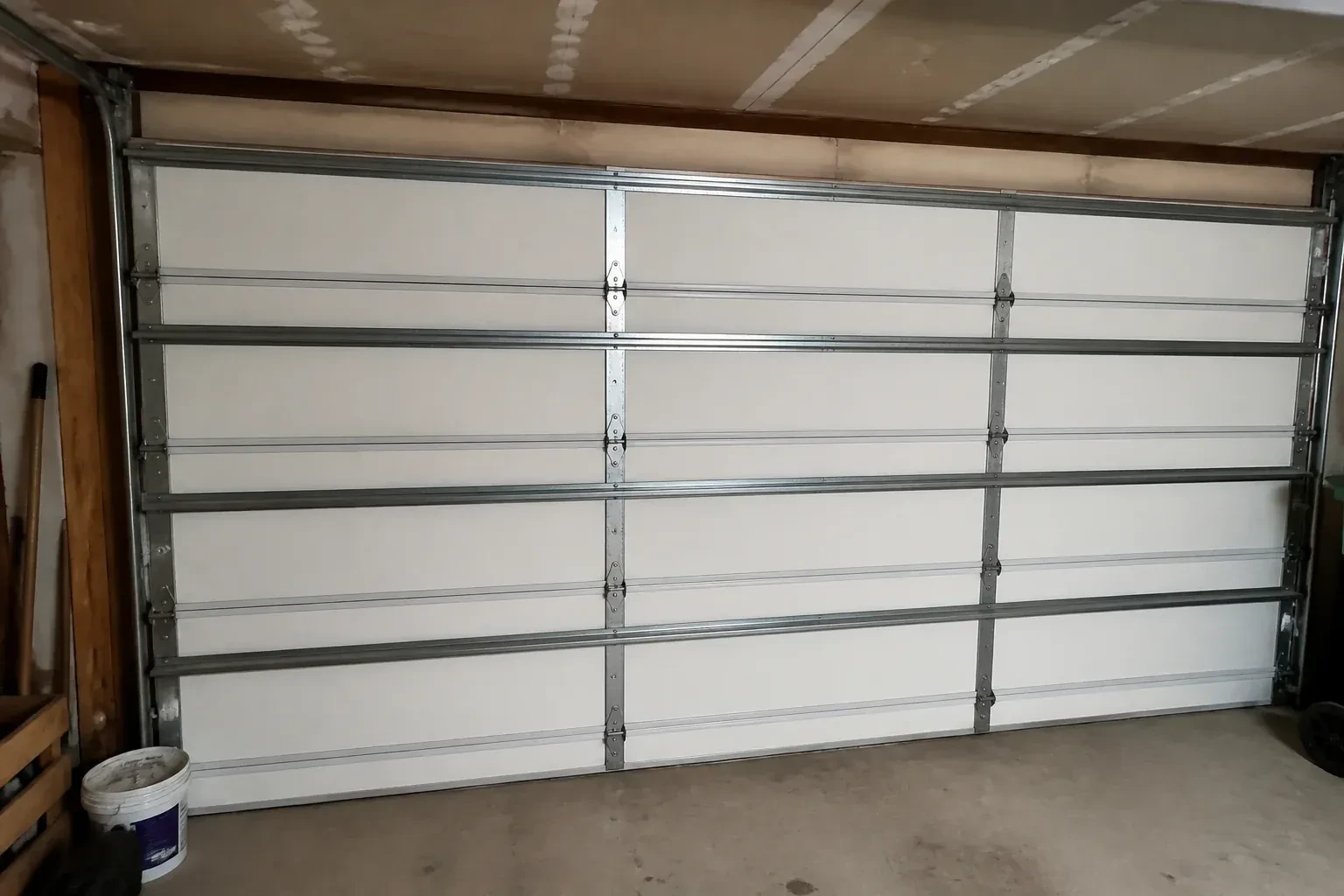 Interior of a closed sectional door with horizontal metal reinforcement struts. — Wind-Rated Garage Door Replacement, Richmond Hill
